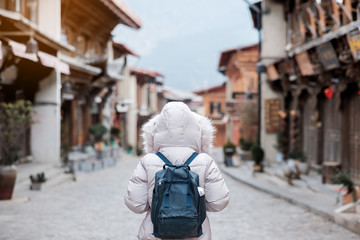 Young woman traveler with sweater traveling in Dukezong old town, located in Zhongdian city (Shangri-La).landmark and popular spot for tourists attractions. Yunnan, China. Asia and Solo travel concept