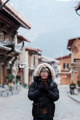 Fototapeta na wymiar Young man traveler with sweater traveling in Dukezong old town, located in Zhongdian city (Shangri-La).landmark and popular spot for tourists attractions. Yunnan, China. Asia and Solo travel concept