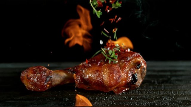 Close-up of falling raw tasty chicken legs on iron cast grate, super slow motion, filmed on high speed cinematic camera at 1000 fps.