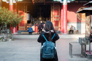 Young woman traveler hand holding incense in Yuantong Temple, Buddhist temple in Kunming. landmark and popular for tourists attractions in Kunming, Yunnan, China. Asia travel concept