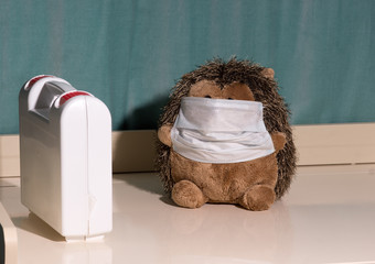 Hedgehog plush toy in a medical mask