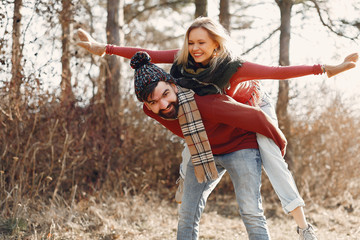 Couple in a cute sweaters. People in a spring forest.