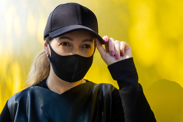 Woman with black protective and medicine mask on yellow background against influenza virus and during pandemic infection. Pandemic coronavirus 2020 and Quarantine. Stop the virus and epidemic diseases