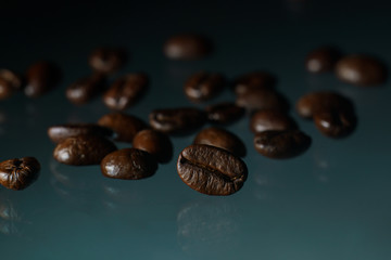 Roasted coffee beans pile on glass reflection background.