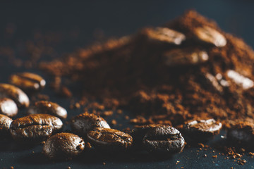Ground coffee and coffee beans on black background.