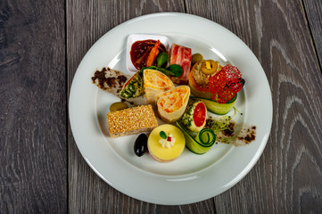 food platter with meat and cheese rolls and vegetables with sauces