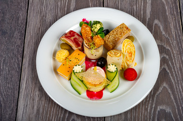 food platter with meat and cheese rolls and vegetables with sauces