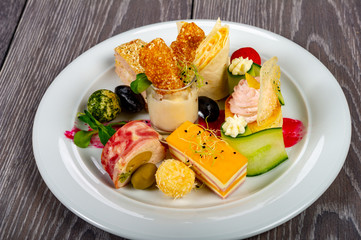 food platter with meat and cheese rolls and vegetables with sauces