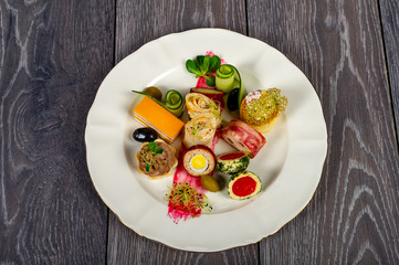 food platter with meat and cheese rolls and vegetables with sauces