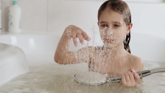Girl plays with water that flows up, 4K UHD still video camera, 2x slow motion.