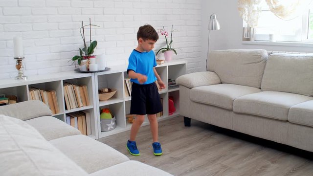 A six years old boy playing soccer football at home during quarantine COVID-19. Life stile in an apartment. 4k