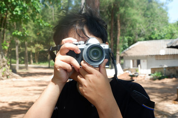 Short haired woman holding an outdoor digital camera