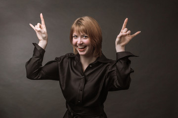 Portrait of redheaded girl, Rock Music fun and laughing a joking gesture