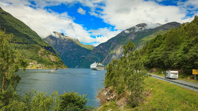 Cruise ship on fjord and camper on road, Norway.