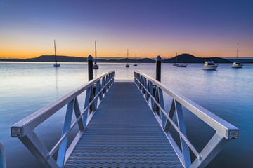 Fototapeta premium Sunrise, boats and wharf waterscape