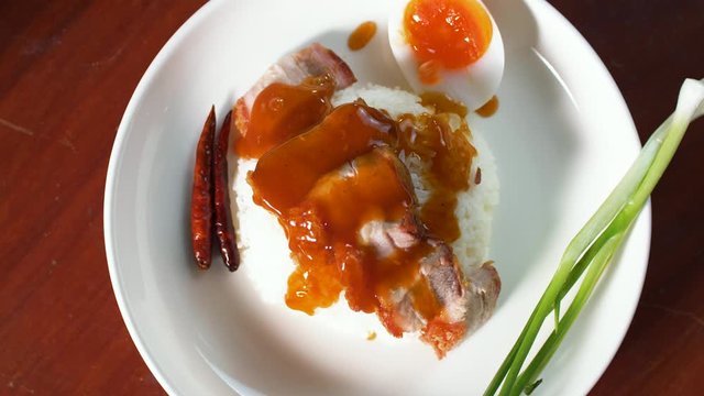 Pouring sweet sauce in to Crispy pork with rice- Khao Moo Grob, is one of the favarite dish. Fried belly pork,  Asian style.