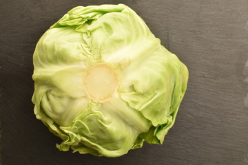 Fresh green cabbage on a slate board, closeup.