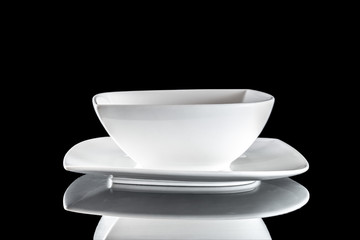 White plate from above for food isolated on black. Round empty dish for dinner on dark background. Restaurant kitchen minimalistic concept.