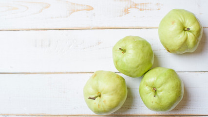 Guavas on white wooden table.