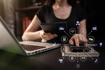Businesswoman working with tablet and using a calculator to calculate the numbers of static in...