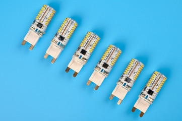 Several LED bulb on blue background. Saving energy concept. Ftat lay, top view, copy space. Bulbs for ceiling lights.