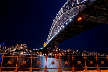 Sydney Harbour Bridge illuminating the harbour and circular quay with vibrant colourful lights at...