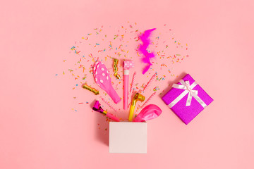 gift box with holiday accessories on a pink background