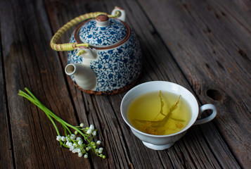 tea with teapot and flowers on wooden background. flowers with tea. 
herbal tea in a white cup. 