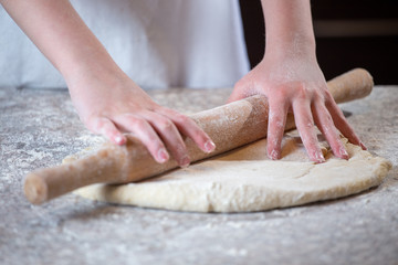 Obraz na płótnie Canvas Girl making pizza dough