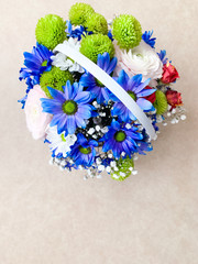 Basket with flowers, a bouquet of flowers blue chrysanthemums on a plain background.