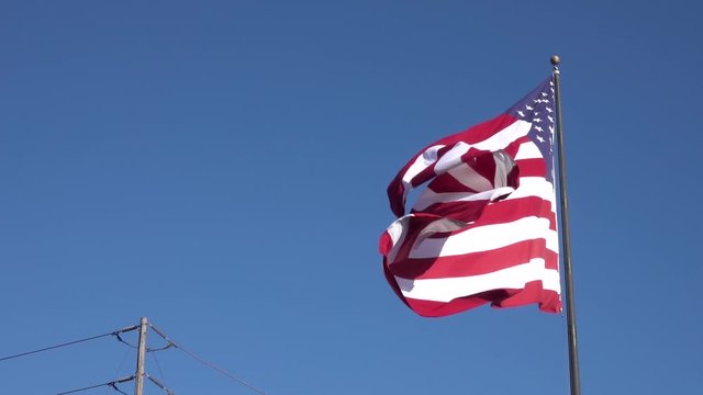American flag against blue sky Flowing in the Wind at Slow Motion