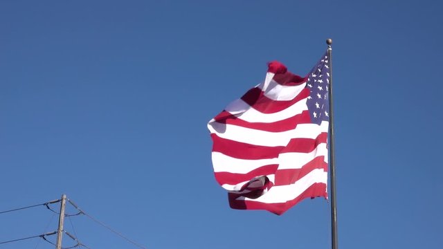 American flag against blue sky Flowing in the Wind at Slow Motion