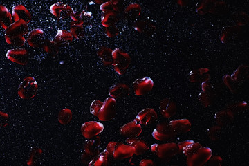 Water drops on ripe sweet pomegranate seeds. Fresh pomegranate background with copy space for your text. Vegan concept.