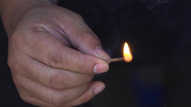 Male's Hand Holding a Burning Match, Blowing it our and Smoking, Close Up Slow Motion 120fps