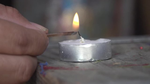 Close Up of Man lighting a small wax candle with a Match
