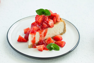 Slice of cheesecake with strawberries, mint and sauce. Selective focus