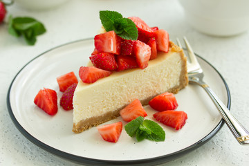 Slice of cheesecake with strawberries, mint and sauce. Selective focus