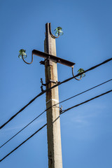 High electric pole against the blue sky.