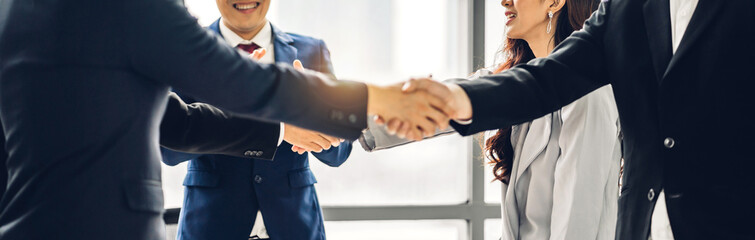 Image two business partners in elegant suit successful handshake together in front of group of casual business clapping hands in modern office.Partnership approval and thanks gesture concept © Art_Photo