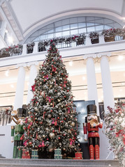 a large beautiful Christmas tree with balls and two huge nutcrackers in a shopping center. New Year.