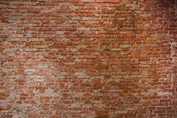 Old brick wall with visible cement stains and leftovers on the bricks. Red brick wall.