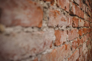 Detail of old brick wall with visible cement stains and leftovers on the bricks. Red brick wall viewed from close angle.