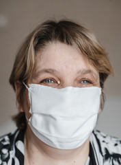 .adult woman with short hair in a medical mask in the room. coronavirus pandemic