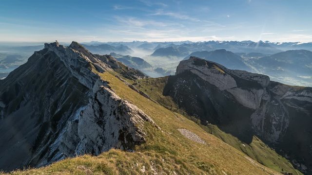 Time lapse of clouds moving over a rocky mountain side on My Pilatus in Switzerland with panoramic views of alpine mountains in the background
