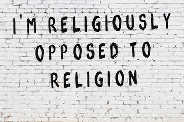 White brick wall with painted black inscription of wise quote