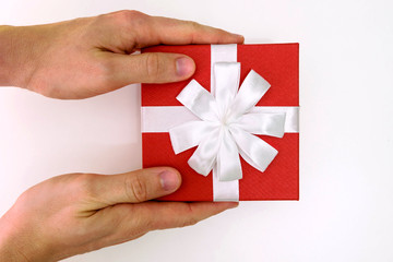 men's hands give a red gift with a white bow, box, isolated on a white background.