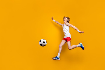 Full length body size view of his he nice funky carefree cheerful cheery glad motivated guy jumping playing soccer having fun isolated over bright vivid shine vibrant yellow color background