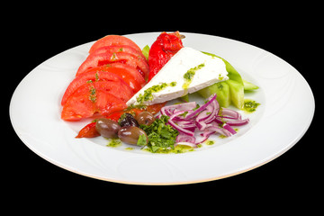 Tasty fresh salad on a plate, isolated on black background.
