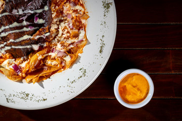 red chilaquiles with beef jerky and hot sauces on the side