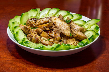Vietnamese lemongrass grill chicken served with sliced cucumber on a big plate